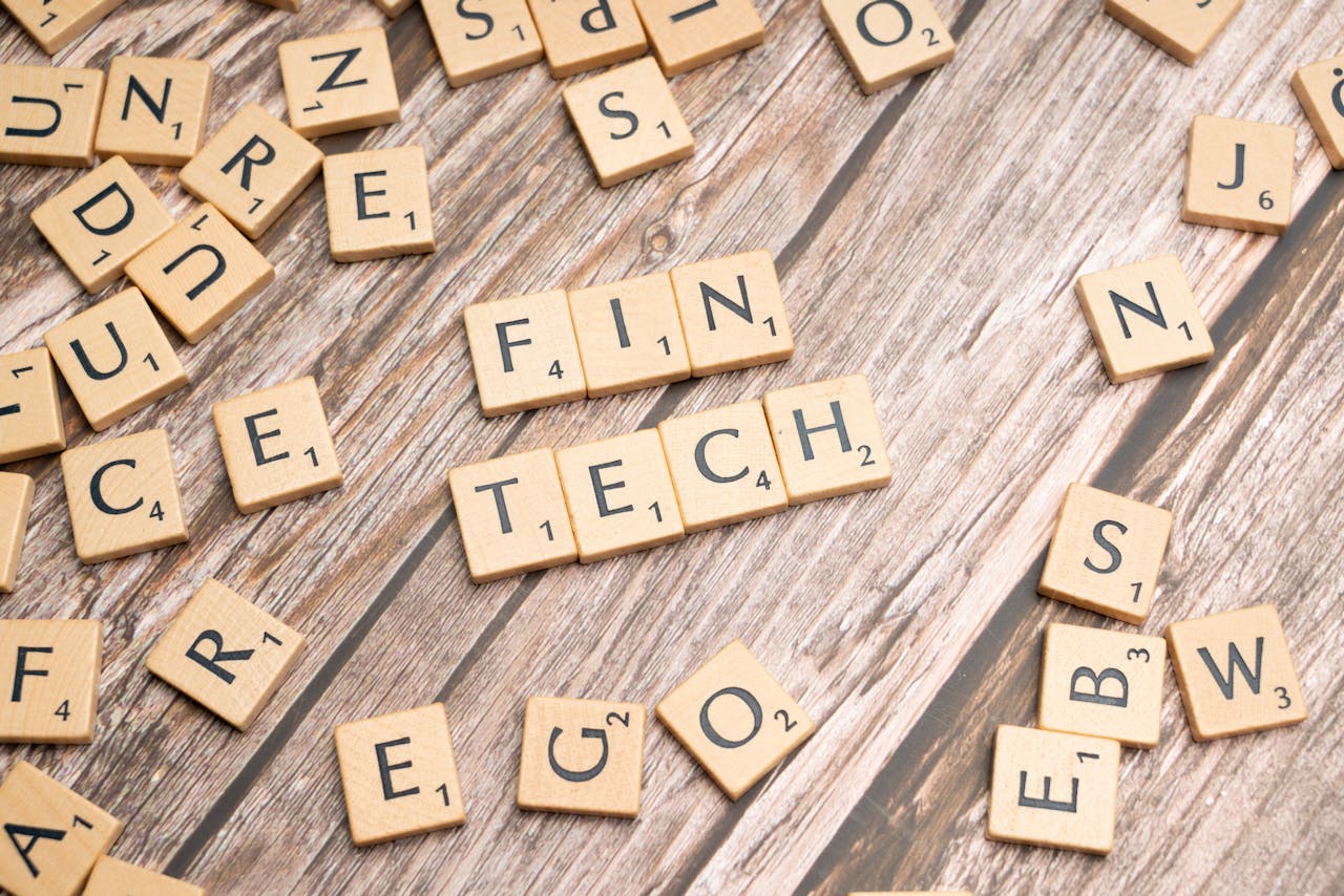 Home Fintech spelled out with wooden letter tiles on a rustic wooden background.